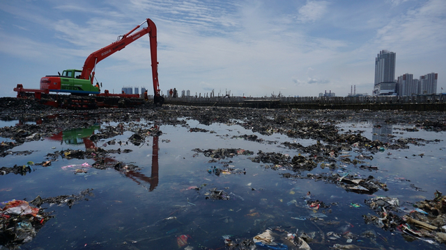 Membersihkan sampah di Teluk Jakarta. Foto: Jamal Ramadhan/kumparan