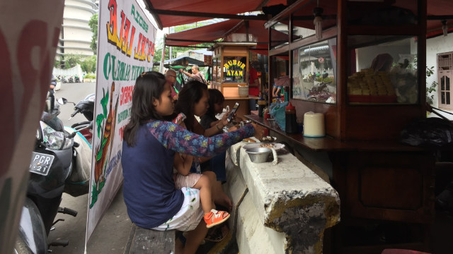 Pembatas jalan jadi meja makan di Jalan Sudirman. (Foto: Soejono Eben Ezer Saragih/kumparan)