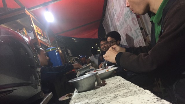 Pembatas jalan jadi meja makan di Jalan Sudirman. (Foto: Soejono Eben Ezer Saragih/kumparan)