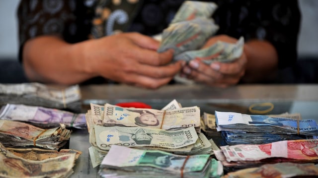 Ilustrasi menghitung mata uang Rupiah lama. (Foto: AFP/Bay Ismoyo)