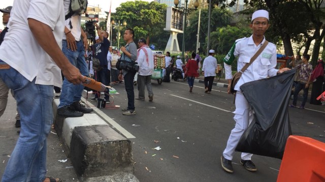 Peserta aksi memunguti sampah sebelum bubar. (Foto: Fachrul Irwinsyah/kumparan)