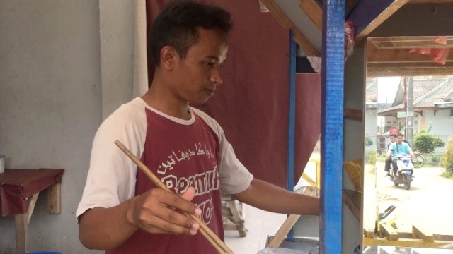 Pak Kentut sedang menyajikan mie ayam. (Foto: Mirsan Simamora/kumparan)