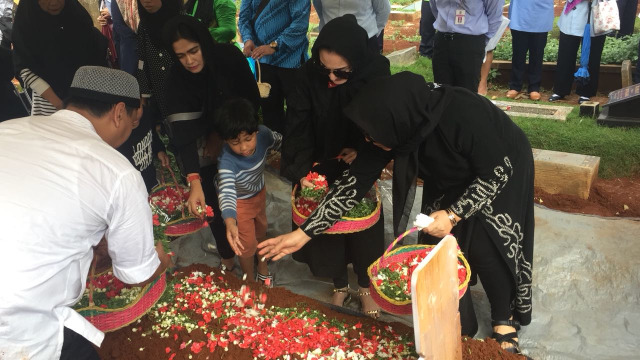 Kiki Amalia menabur bunga di makam sang ayah. (Foto: Alexander Vito/kumparan)