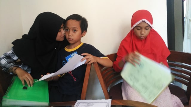 Rina bersama anak kedua dan ketiganya. (Foto: Arfiansyah Panji Purnandaru/kumparan)