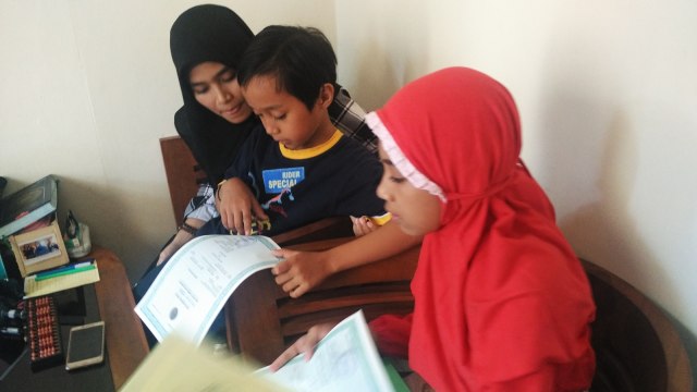 Rina bersama anak kedua dan ketiganya. (Foto: Arfiansyah Panji Purnandaru/kumparan)