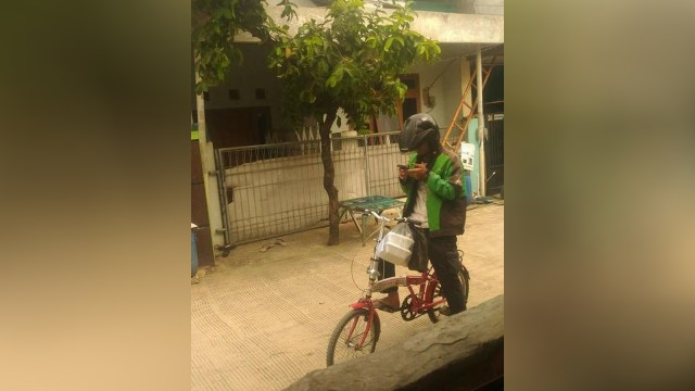 Driver ojek online terima orderan dengan sepeda. (Foto: Instagram @gojek24jam)