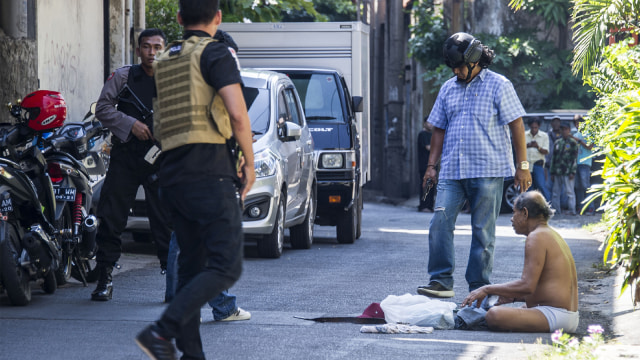 Polisi memeriksa warga usai terjadi bom (Foto: AFP PHOTO / JUNI KRISWANTO)