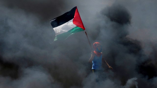 Warga mengibarkan bendera Palestina. (Foto: REUTERS / Mohammed Salem)