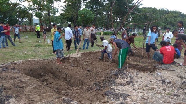 Warga menutup liang kubur yang sudah di gali. (Foto: Phaksy Sukowati/kumparan)