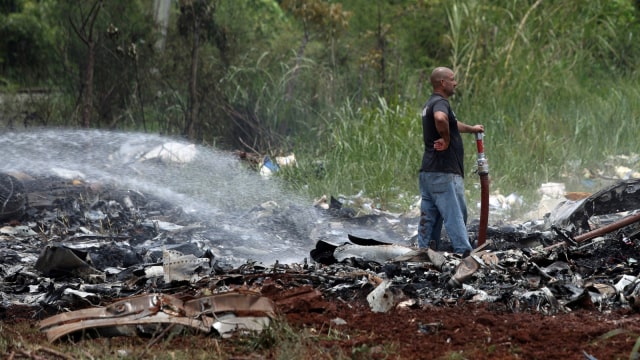 Petugas di hamparan puing pesawat jatuh di Kuba. (Foto: REUTERS/Alexandre Meneghini)