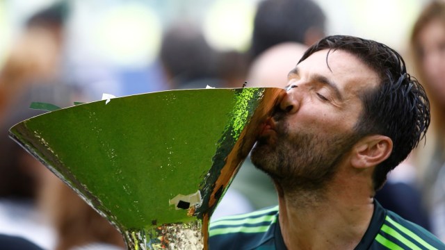 Buffon mencium trofi juara Serie A. (Foto: Reuters/Stefano Rellandini)