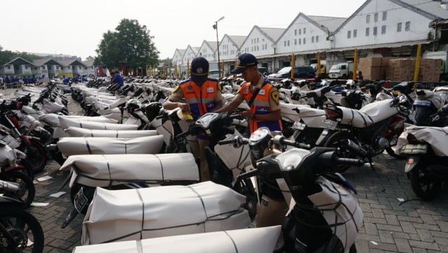 Pekerja menyiapkan motor yang akan dipaketkan. Foto:  Fitra Andrianto/kumparan