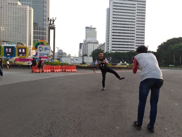 Masyarakat berfoto di bundaran HI yang sepi. (Foto: Paulina Herasmaranindar/kumparan)