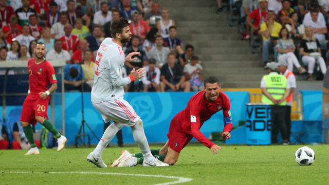 Cristiano Ronaldo dijatuhkan oleh Gerard Pique. (Foto: Hannah McKay/Reuters)