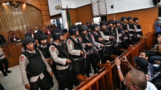 Petugas polisi menutupi Aman saat sujud. (Foto: Aditia Noviansyah/kumparan)