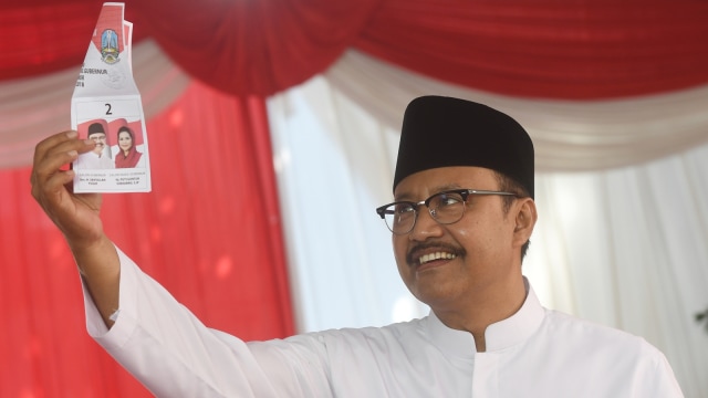 Gus Ipul menunjukan surat suara di TPS. (Foto: Antara/Zabur Karuru)