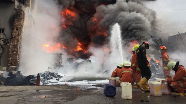 Petugas dibantu warag berusaha memadamkan kebakaran di Kampung Bandan. (Foto: Fachrul Irwinsyah/kumparan)