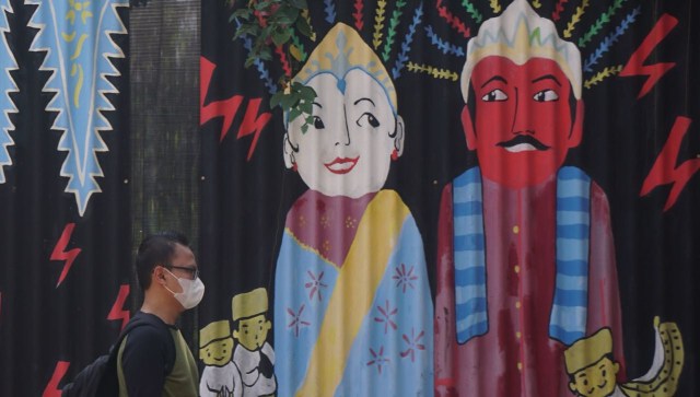 Pejalan kaki melintasi lukisan mural ondel-ondel di kawasan Kuningan Barat. (Foto:  Fanny Kusumawardhani/kumparan)