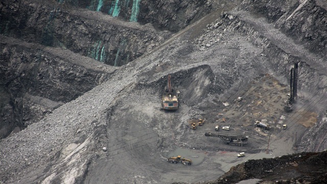 Kendaraan berat mengumpulkan bebatuan dengan endapan emas di kompleks pertambangan Grasberg Freeport McMoRan. (Foto: AFP PHOTO / Olivia Rondonuwu)