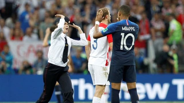 Seorang penginvasi lapangan melakukan tos dengan Kylian Mbappe. (Foto: Reuters/Darren Staples)