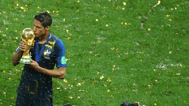 Raphael Varane dengan trofi Piala Dunia. Foto: REUTERS/Michael Dalder