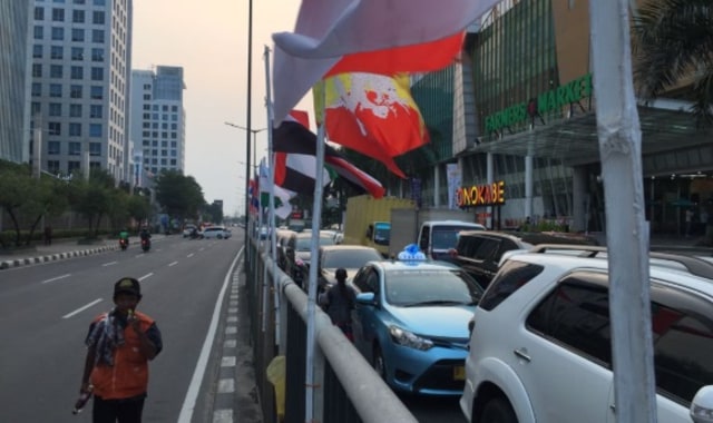 Bendera peserta Asian Games dipasang seadanya dengan bambu di Pluit (Foto: Fachrul Irwinsyah/kumparan)