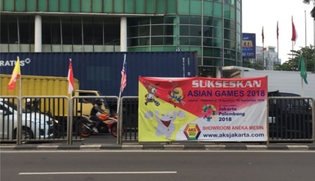 Bendera peserta Asian Games dipasang seadanya dengan bambu di Pluit (Foto: Fachrul Irwinsyah/kumparan)