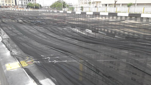 Kali Item di sekitar Wisma Atlet Kemayoran ditutupi jaring tipis untuk menutupi bau dan warna hitam airnya (Foto: Istimewa)