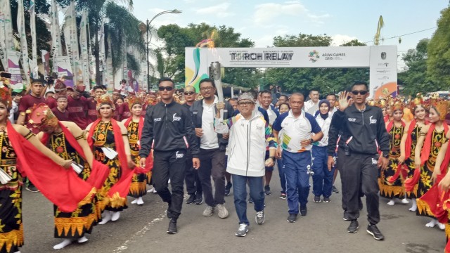 Bupati Banyuwangi Abdullah Azwar Anas membawa api obor Asian Games menuju Pendopo Sabha Swagata Blambangan, Banyuwangi. (Foto: Nabilla Fatiara/kumparan)