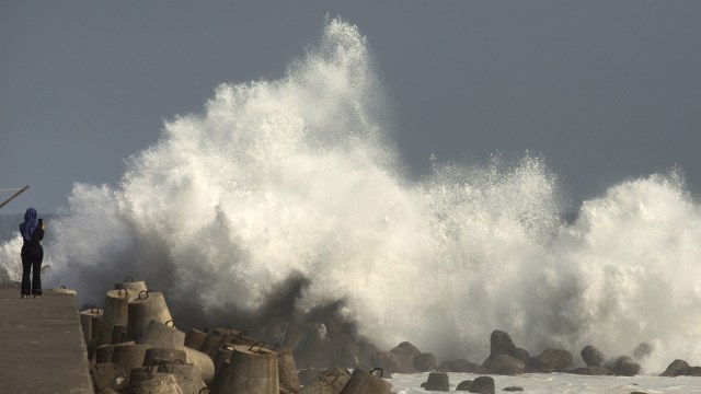 Wisatawan mengamati ombak tinggi di kawasan wisata Pantai Glagah, Temon, Kulonprogo, Daerah Istimewa Yogyakarta (DIY), Jumat (20/7). Foto: ANTARA FOTO/Andreas Fitri Atmoko