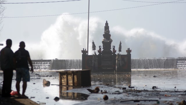 Warga menyaksikan aktivitas gelombang tinggi menghantam sejumlah bangunan pura di kawasan Pantai Padang Galak, Denpasar, Bali, Rabu (25/7). (Foto: ANTARA FOTO/Wira Suryantala)