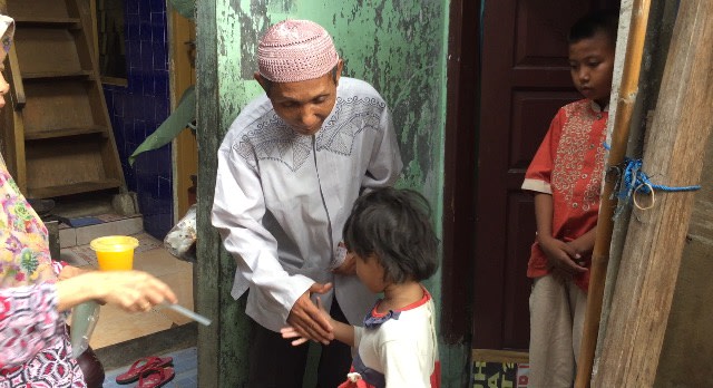 Sarono, tukang pemecah batu, membagikan uang pada anak yatim. (Foto: Fachrizal H./kumparan)
