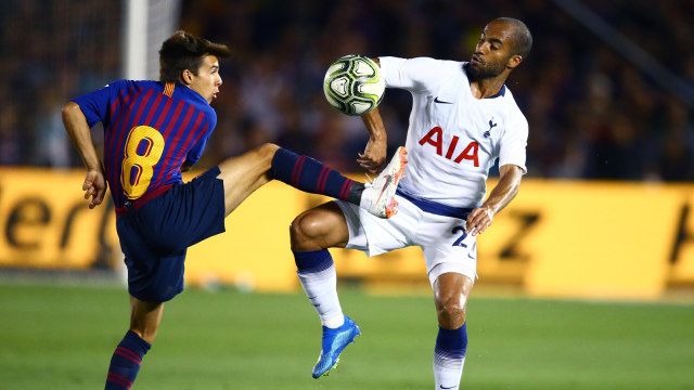 Lucas Moura berduel dengan salah satu pemain Barcelona. (Foto: Mark J. Rebilas/Reuters)
