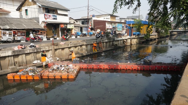 Sejumlah petugas membersihkan sampah yang menggenang di Kali Item, Kemayoran, Jakarta (30/7). (Foto: Fitra Andrianto/kumparan)