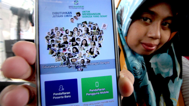 Warga menunjukan aplikasi digital dari Badan Penyelenggara Jaminan Sosial (BPJS) Kesehatan saat sosialisasi di Kabupaten Bogor, Jawa Barat, Senin (30/7). (Foto: ANTARA FOTO/Yulius Satria Wijaya)