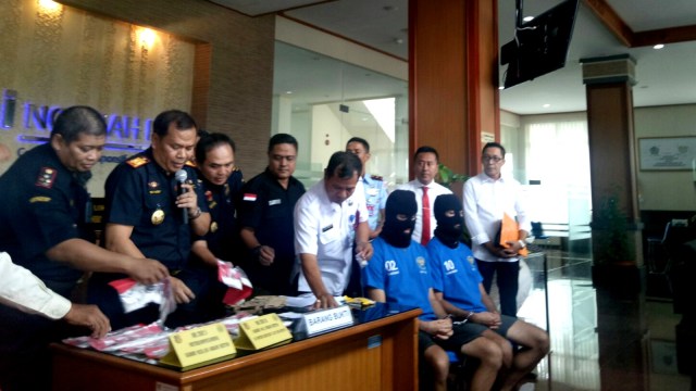 2 dari 3 WNA tersangka pembawa ganja dari Chile dan Inggris serta barang bukti di Bea Cukai Ngurah Rai, Badung, Bali, Rabu (1/8). (Foto: Cisilia Agustina Siahaan/kumparan)