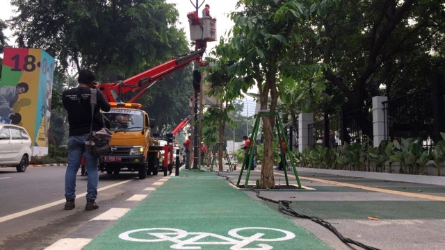 Sudin PE Jakarta Pusat membongkar tiang lampu yang mengganggu jalur sepeda di Gelora Bung Karno, Rabu (8/1). (Foto: Fachrul Irwinsyah/kumparan)