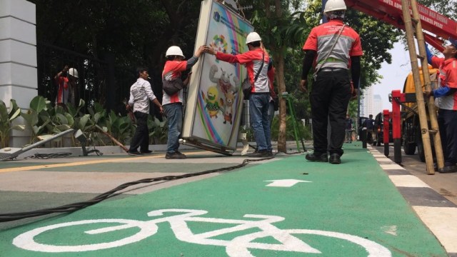 Sudin PE Jakarta Pusat membongkar tiang lampu yang mengganggu jalur sepeda di Gelora Bung Karno, Rabu (8/1). (Foto: Fachrul Irwinsyah/kumparan)