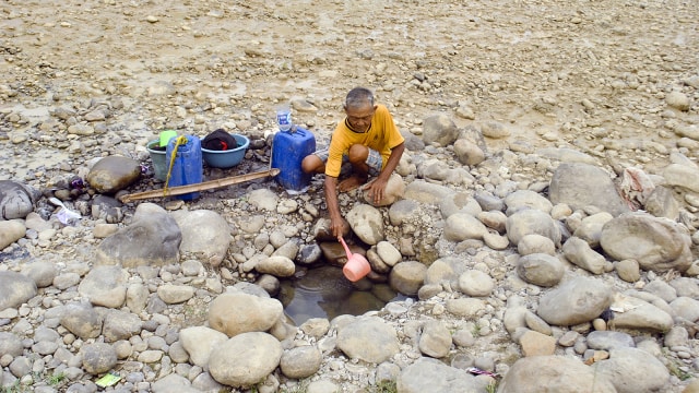 Warga mengambil air dari dasar sungai Cipamingkis yang kering di Jonggol, Kabupaten Bogor, Jawa Barat, Kamis (2/8). (Foto: ANTARA FOTO/Arif Firmansyah)