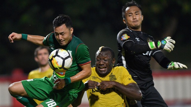 Pesepak bola Bhayangkara FC Herman Dzumafo (tengah) dan penjaga gawang Bhayangkara FC Wahyu Tri Nugroho (kanan) berebut bola dengan pesepak bola PSMS Medan Matsunaga pada pertandingan Gojek Liga 1 2018 di Stadion PTIK, Jakarta Selatan, Jumat (3/8) malam. Bhayangkara FC menang dengan skor 3-1. (Foto: ANTARA/Sigid Kurniawan)