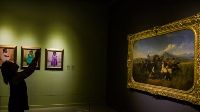 Pengunjung melihat lukisan yang dipajang pada Pameran Seni Koleksi Istana Kepresidenan Republik Indonesia di Galeri Nasional, Jakarta, Jumat (3/8). (Foto: Antara/Galih Pradipta)