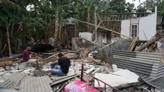 Warga berada di puing reruntuhan bangunan di Dusun Wadon, Desa Kekait, Kecamatan Gunung Sari, Kab. Lombok Utara, NTB, Senin (6/8). (Foto: Jamal Ramadhan/kumparan)