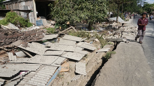 Warga berada di puing reruntuhan bangunan di Dusun Wadon, Desa Kekait, Kecamatan Gunung Sari, Kab. Lombok Utara, NTB, Senin (6/8). (Foto: Jamal Ramadhan/kumparan)