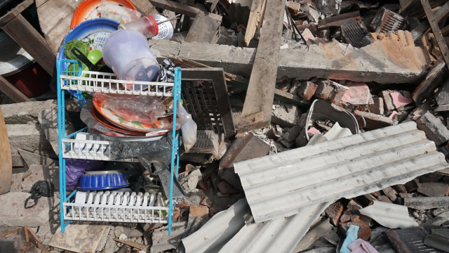 Rak piring yang tersisa di antara puing reruntuhan bangunan di Dusun Wadon, Desa Kekait, Kecamatan Gunung Sari, Kab. Lombok Utara, NTB, Senin (6/8). (Foto: Jamal Ramadhan/kumparan)