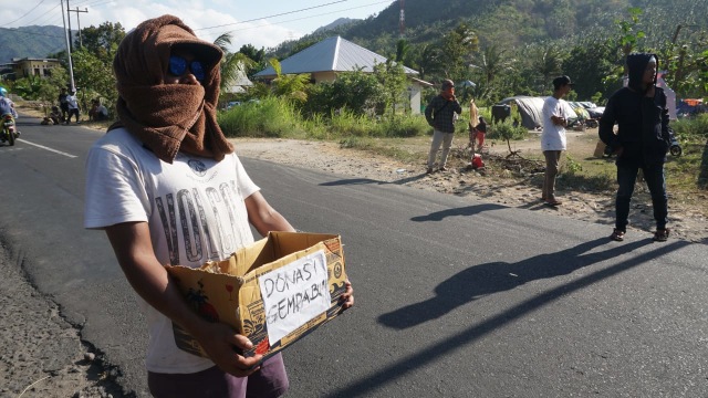 Pemuda di Desa Menggala menggalang donasi korban gempa di Desa Menggala, Kec. Pemenang, Kab. Lombok Utara, NTB, Senin (6/8). (Foto: Jamal Ramadhan/kumparan)