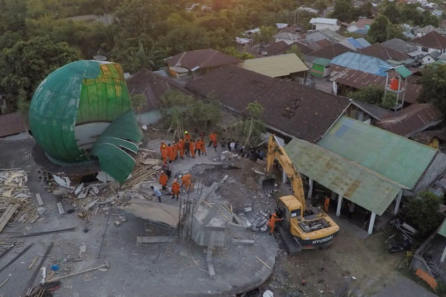 Petugas tim gabungan SAR mengevakuasi korban gempa yang tertimpa bangunan masjid di Dusun Lading-lading, Desa Tanjung, Kecamatan Tanjung, Kabupaten Lombok Utara, Nusa Tenggara Barat, Senin (6/8). (Foto: Jamal Ramadhan/kumparan)