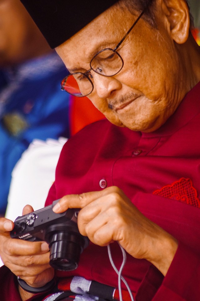 Presiden ke-3 Republik Indonesia B.J. Habibie melihat hasil foto di kamera digitalnya saat menghadiri Peringatan HUT ke-61 Provinsi Riau di Kota Pekanbaru, Kamis (9/8). Foto: ANTARA FOTO/Retmon