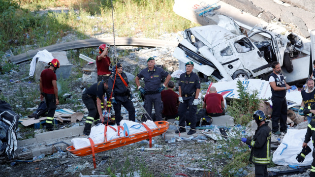 Para petugas membantu evakuasi korban terjadinya jembatan Morandi yang ambruk, Genoa, Italia (15/8/2018). (Foto: REUTERS/Stefano Rellandini)