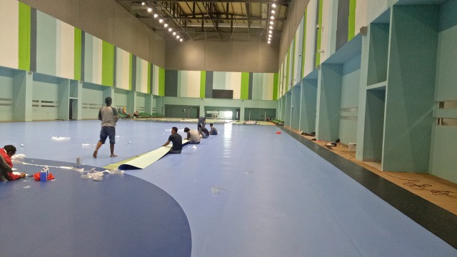 Para pekerja sedang memasang lantai lapangan hand ball di lantai delapan GBK Arena, Rabu (15/8). (Foto: Aditia Rijki Nugraha/kumparan)
