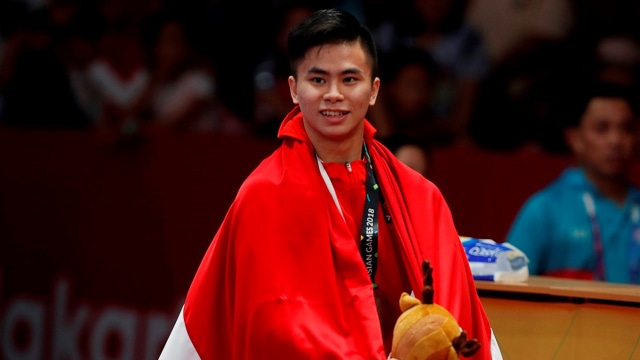 Edgar Marvelo berbalut bendera merah-putih. (Foto: Reuters/Beawiharta)